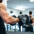 Bras musclé soulevant un haltère dans un gymnase